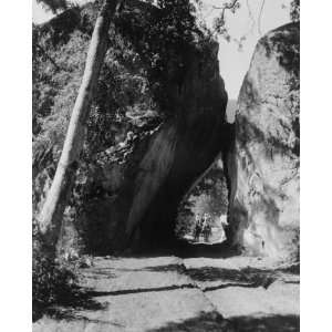 1913 photo Horse drawn carriage coming through Arch Rock, a large rock 