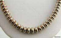 This chunky silver necklace has flattened round beads, with a polished 
